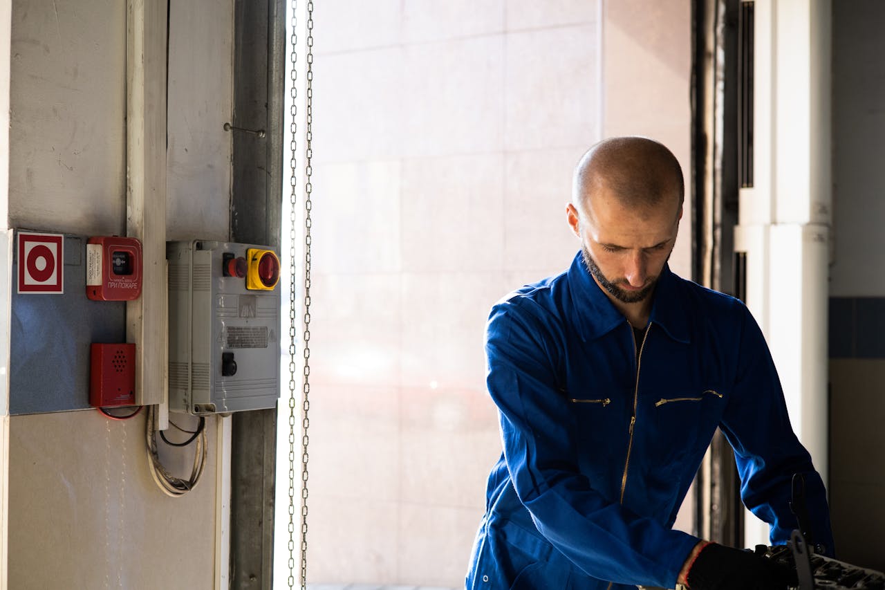 Caucasian male technician working indoors with PPE in industrial setting.